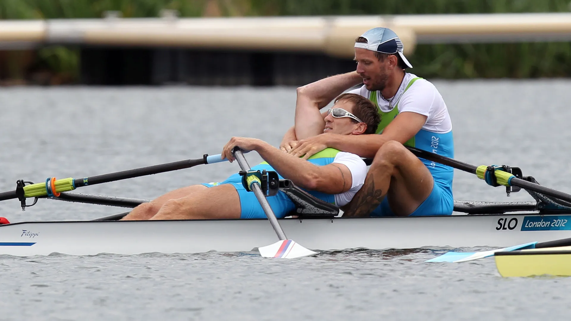 Slovenska veslača se objemata v čolnu po tekmi na olimpijskih igrah v Londonu 2012.