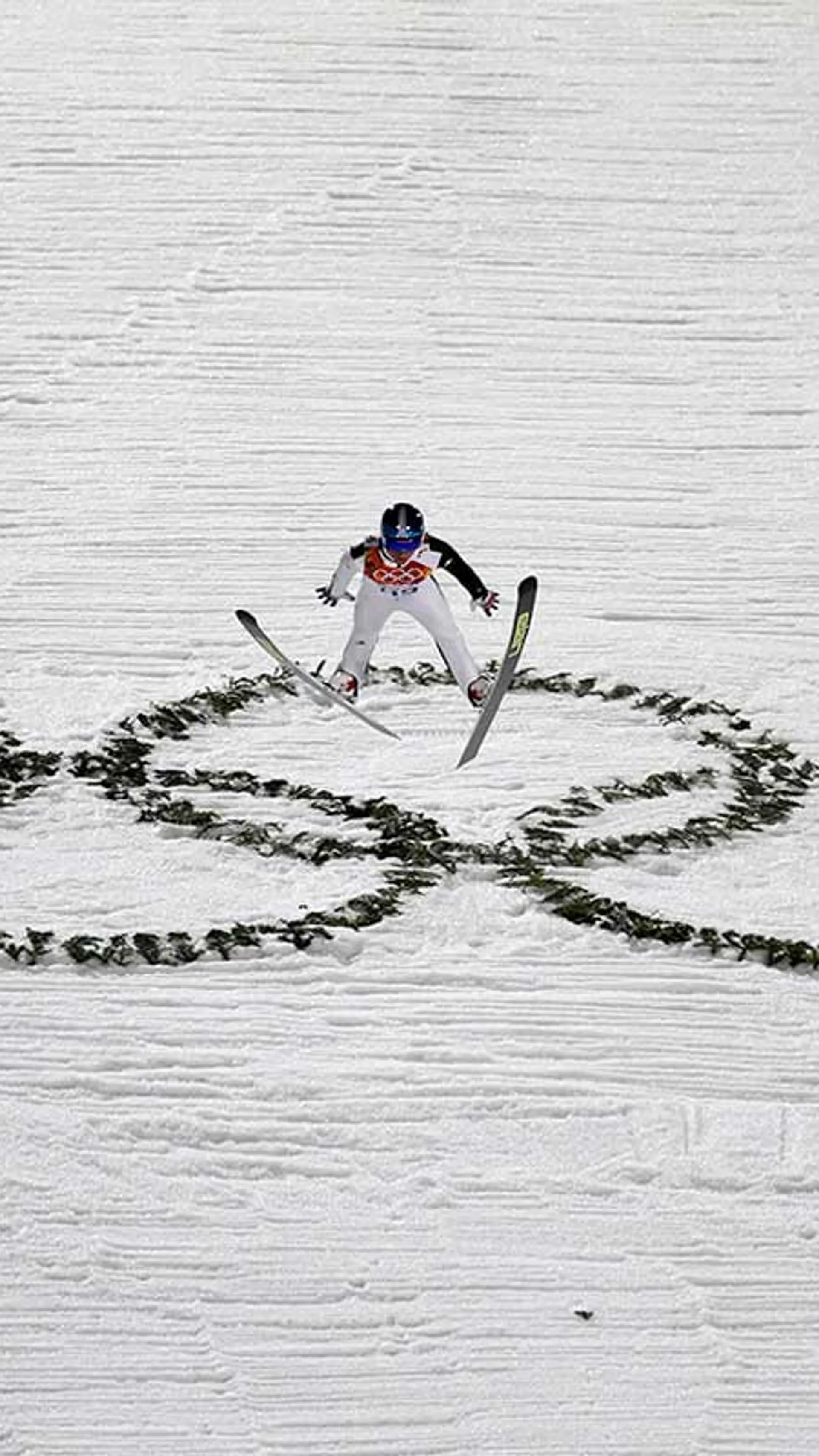 Smučarski skok na olimpijskih igrah, pod njim pa so vidni olimpijski krogi